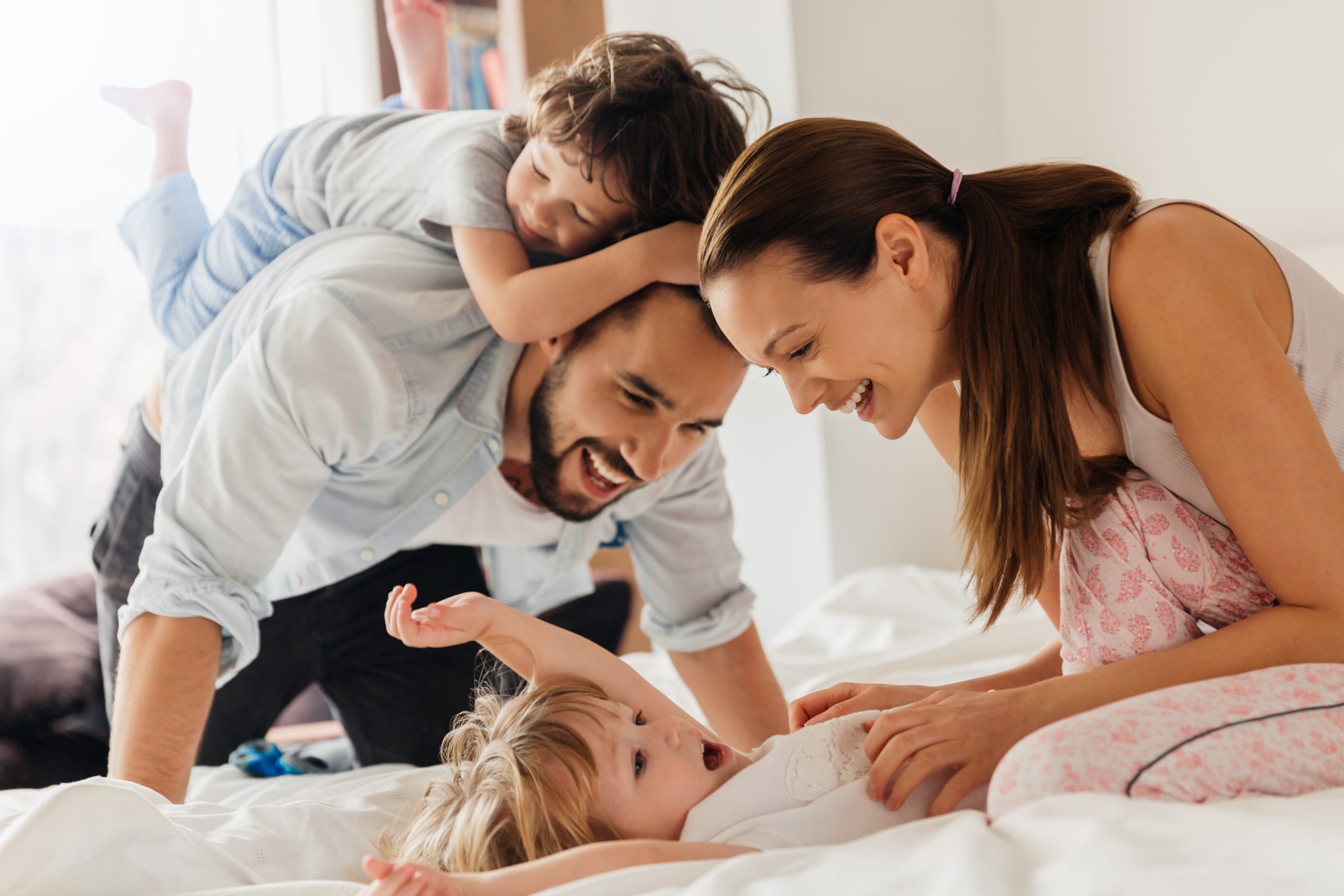 Happy,Family,Playing,And,Laughing,Together,On,Bed,In,The Private Healthcare Insurance UK