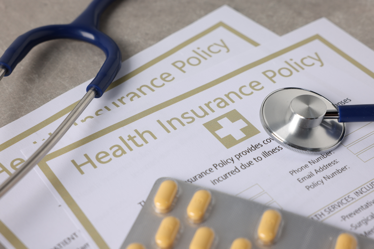 Health,Insurance,Policy,Forms,,Pills,And,Stethoscope,On,Grey,Table, switch health insurance plans
